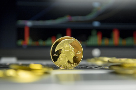 金色泰坦比特币硬币，金币躺在笔记本电脑的银色键盘上，屏幕上的图表作为背景。