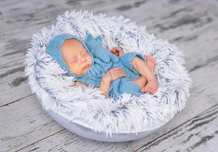 可爱圆摄影照片_戴着帽子和连衣裤睡在圆床上的可爱婴儿