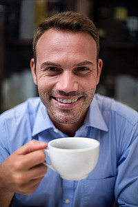 拿着咖啡杯的快乐男人的特写肖像