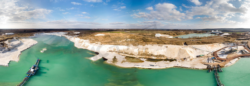 航空照片和白色石英砂湿法采矿作业航拍照片的合成全景，带有绿色和蓝色的防空洞湖和大型抽吸式挖泥船。