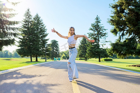 青少年体育摄影照片_阳光明媚的夏日，在公园路上跳舞的年轻女青少年