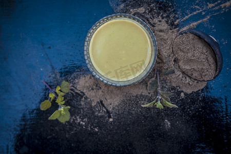 Ayurvedic 草本 brahmi 或 Waterhyssop，将其有益的糊状物放入玻璃碗中，并在木质表面上涂上粉末。