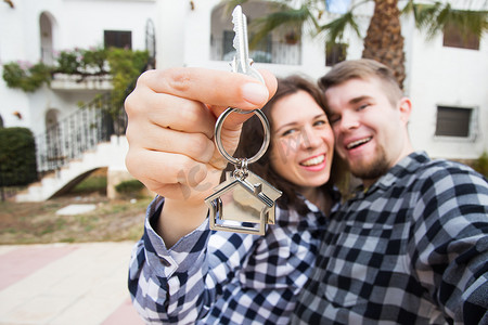 财产、房地产和租金概念 — 快乐有趣的年轻夫妇展示新房的钥匙