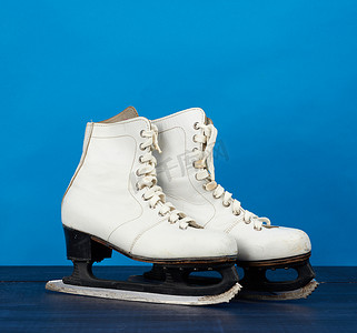 蓝色木 b 上的花样滑冰用白色皮革溜冰鞋