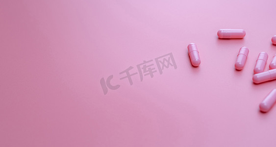 粉红色背景上的粉红色胶囊药丸，带有复制空间。
