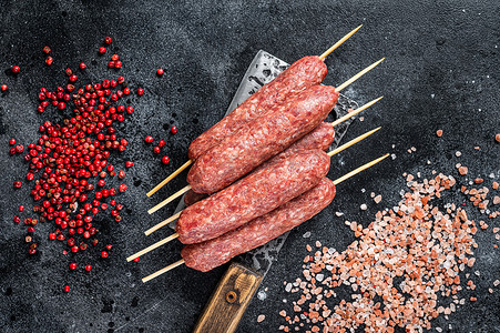 生卢拉或科夫塔烤肉串放在屠夫切肉刀上，加盐和胡椒。