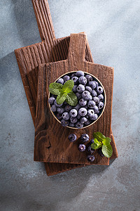 一碗新鲜的蓝莓在质朴的木板上。
