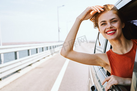 开朗的女人从车窗外偷看旅行公路旅行