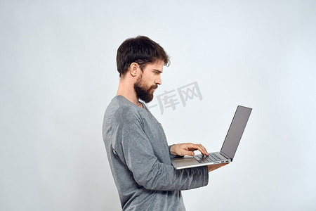 手拿笔记本电脑的大胡子男子互联网通信技术浅色背景