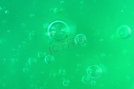 透明发光气泡摄影照片_浅色单色背景上带有气泡和波浪的透明绿色凝胶的纹理
