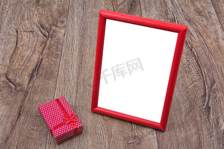 礼物盒盒相框摄影照片_木制背景上有礼物的相框