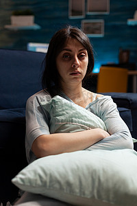 抑郁、脆弱、压力大、绝望的女人独自坐在沙发上看着镜头