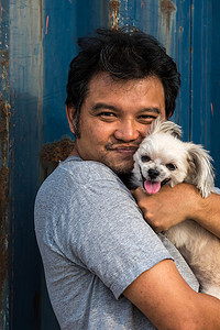亚洲男人和狗开心地拥抱容器