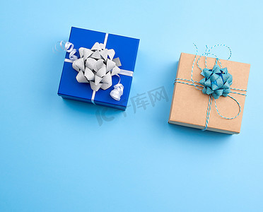 蓝色上装饰着丝带和蝴蝶结的两个方形礼盒