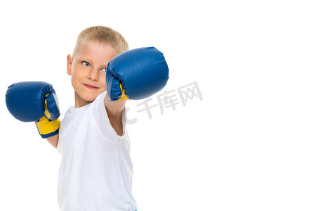 一个穿着干净白色T恤、戴着拳击手套的小男孩。