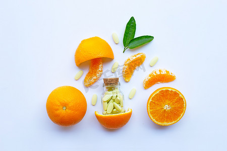 白色背景中带有橙色水果的维生素 C 瓶和药丸