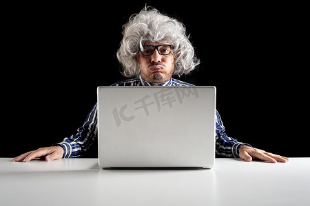 一位老人婴儿潮一代在使用电脑时打喷嚏