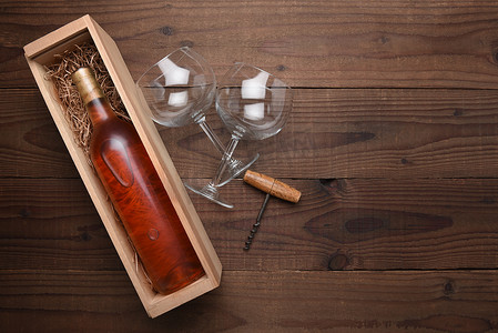红酒瓶红酒杯摄影照片_带眼镜的木盒中的腮红酒瓶