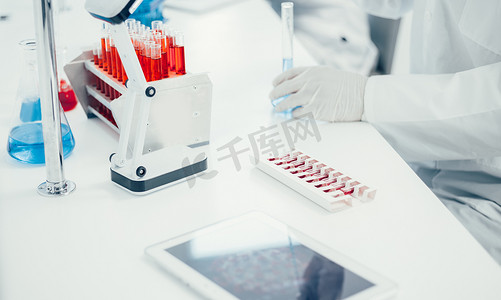 实验室桌子上放着疫苗的数字平板电脑和安瓿。