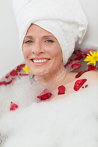 放松的女人，头上戴着毛巾，正在放松地洗澡