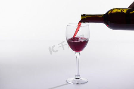 红酒瓶在白色背景上倒玻璃，并带有复制空间