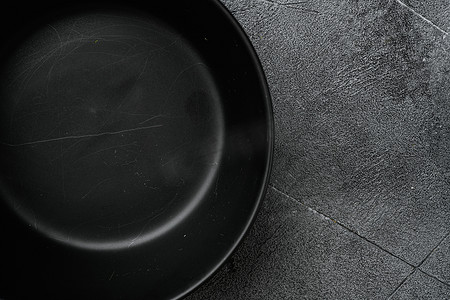 餐具托盘摄影照片_空黑碗，有文本或食物的复制空间，有文本或食物的复制空间，顶视图平躺，灰色石桌背景