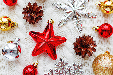 圣诞和新年背景与装饰-球、星星、银色闪闪发光的雪花在针织面料上带有装饰图案。