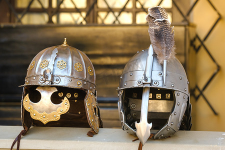 战士背景摄影照片_两个骑士的头盔躺在表面上。中世纪的概念