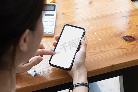 年轻女孩手拿着手机触摸手指模型白色空白显示屏，家里社交媒体应用广告的空屏幕。