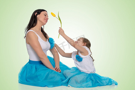 花束妈妈摄影照片_妈妈和女儿有一朵郁金香花。