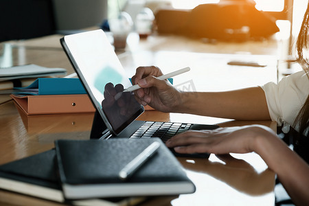 商人在工作时使用电子笔，男人在办公桌上使用带有平板电脑的手写笔进行财务计算。