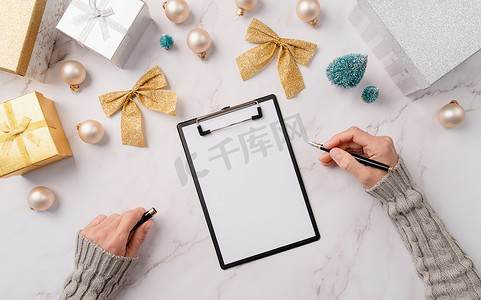 顶视图手在白纸上写新年目标、决议或购物清单。