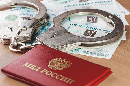 上锁的手铐、内务部雇员证明和俄罗斯纸币。