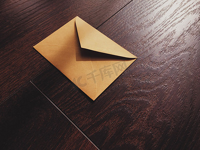 金色信封摄影照片_木制背景、时事通讯和消息上的金色复古信封