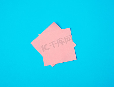蓝色背景上的粉红色空纸方形贴纸