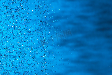 水泡沫水花摄影照片_水溅在蓝色背景上。