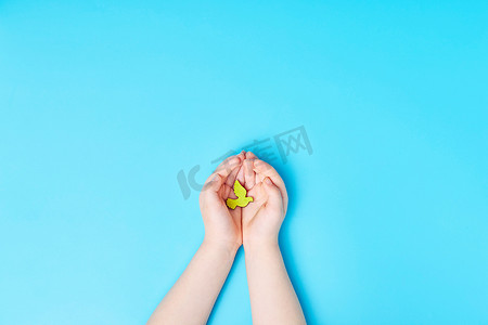 儿童手握蓝色背景的黄鸽鸟、国际和平日或世界和平日概念。