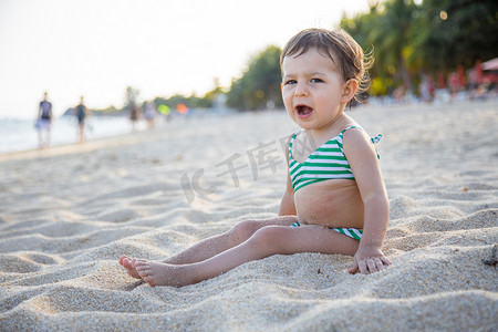 疲惫的小孩在海滩上打哈欠