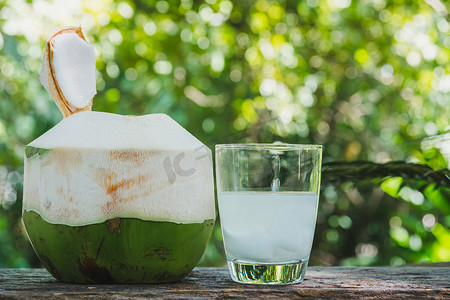 木桌上玻璃杯中的新鲜有机椰子水。