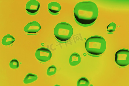 绿色滴落摄影照片_黄色上绿色滴的抽象背景