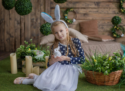 戴着兔子耳朵和 hol 在复活节玩得开心的女孩的画像