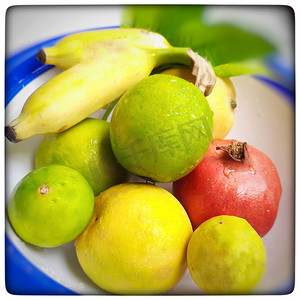 健康的水果在白碗里保存得很漂亮，并配有叶子和健康的食物和维生素 c 健​​康的日常水果