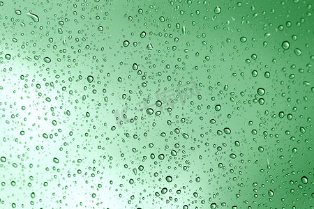 玻璃镜子背景上的雨水滴绿色。