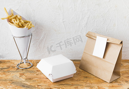 安全食品摄影照片_炸薯条食品包裹模拟木桌面