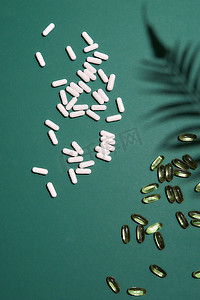 药片图案摄影照片_彩色背景上的许多白色胶囊药片。