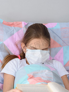 读书器摄影照片_生病的女孩决定一边看书一边睡着，并把医用口罩拉到脸上