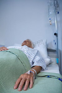 医院床上带生理盐水的老年病人手