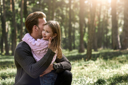 小女孩在森林里拥抱她的父亲