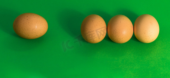 一个挨一个摄影照片_复活节的抽象画，三个鸡蛋挨得很近，一个悲伤的鸡蛋更远，在草绿色的背景中