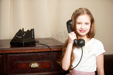 一个小女孩正在用旧电话响铃。